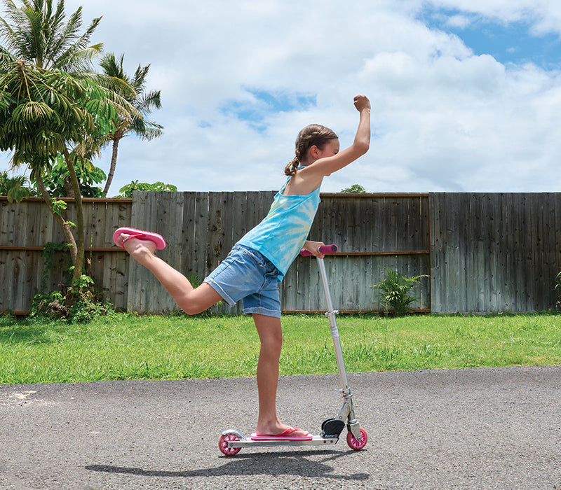 Girl riding a razor scooter wearing Locals slippahs