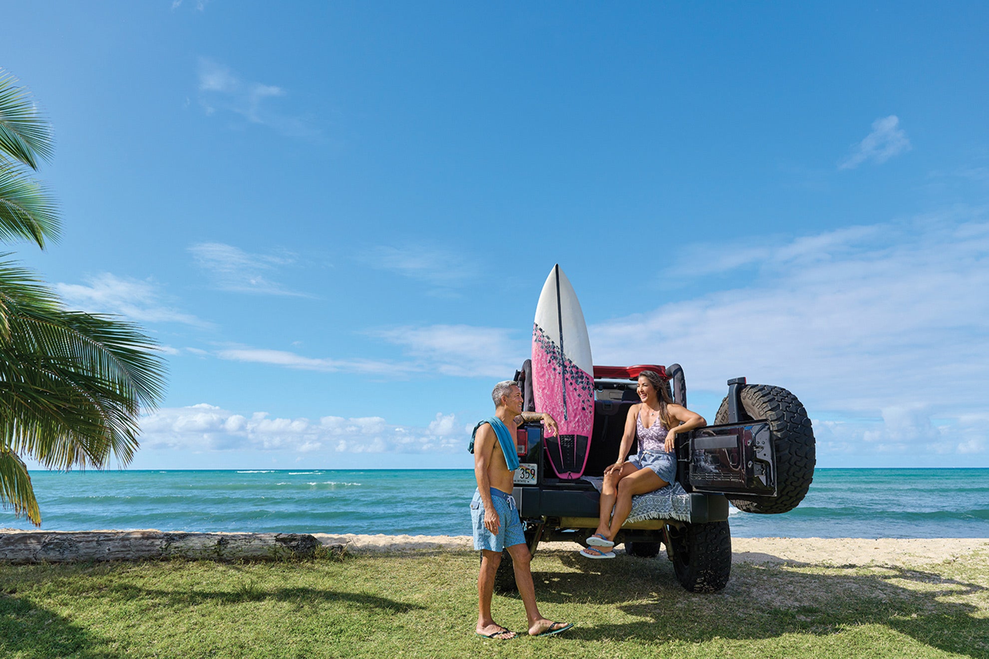 Man and woman next to a Jeep and surboard wearing Locals slippahs