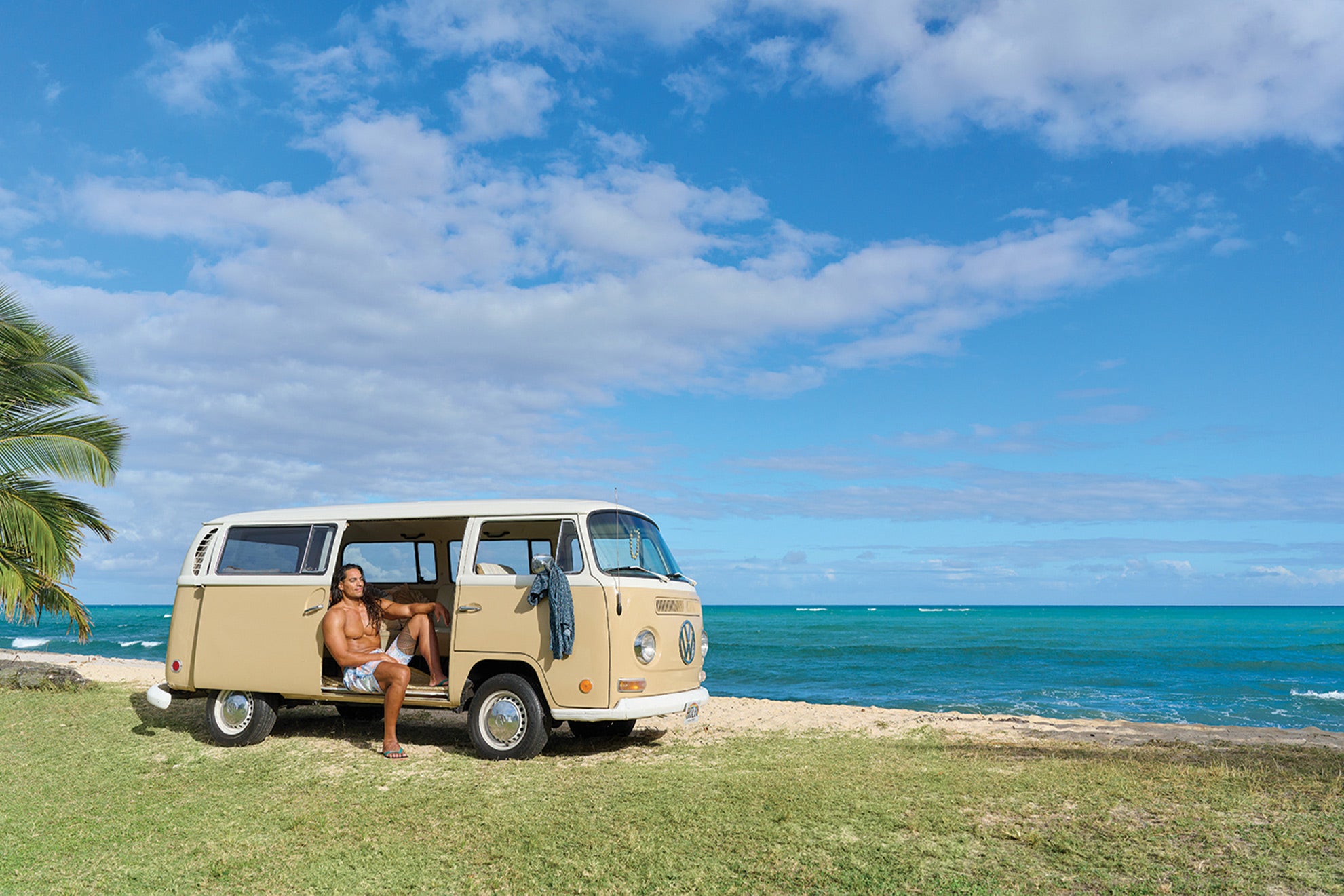 Man in a VW bus sitting on beach wearing Locals slippahs