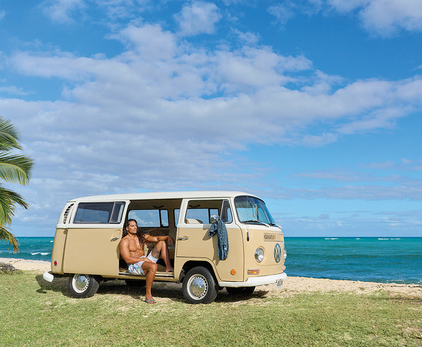Man sitting in VW on beach wearing Locals slippahs